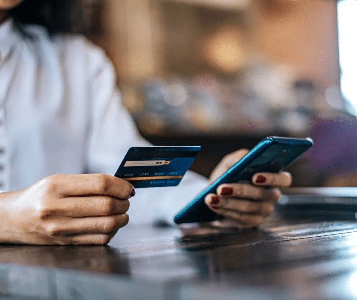 Mujer sosteniendo celular y tarjeta