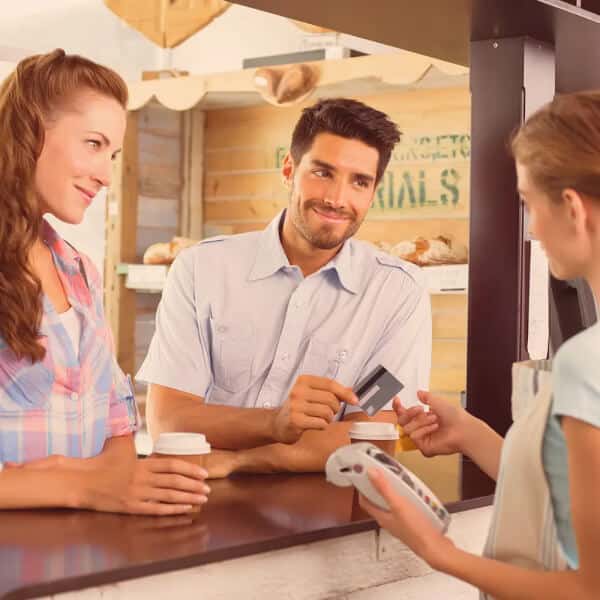 Pareja pagando con tarjeta en un establecimiento