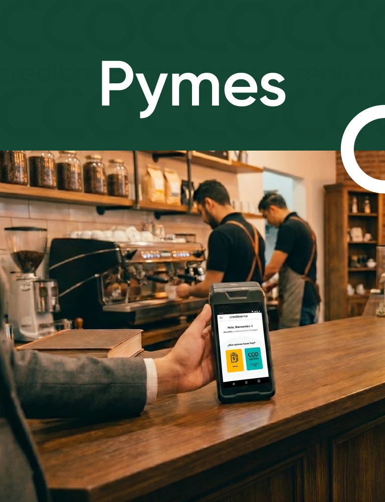 Banner de Pymes con una persona realizando un pago mediante una tablet en la barra de una cafetería, mientras dos trabajadores atienden el negocio al fondo.